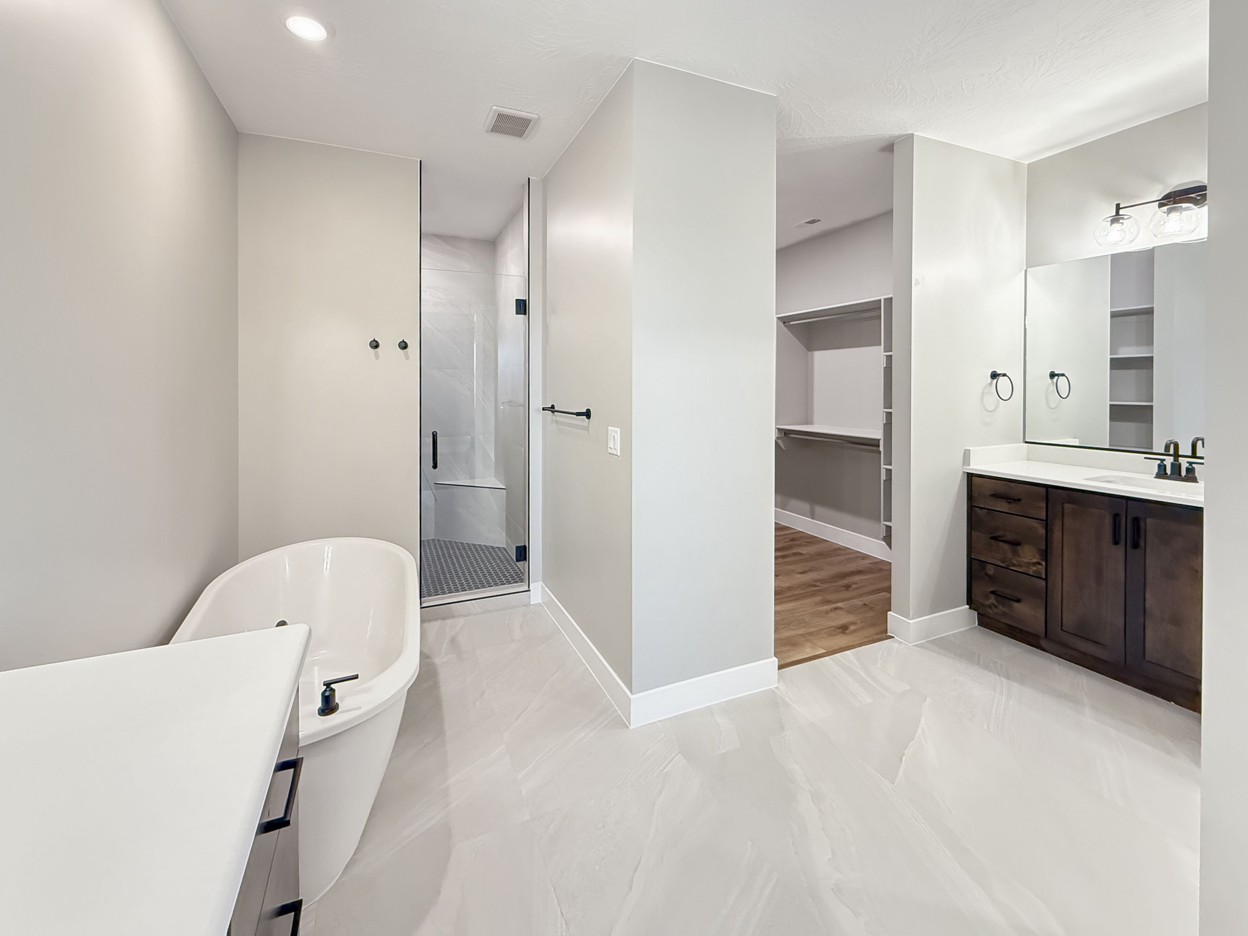 Spa-inspired wet room bathroom with curbless shower, freestanding tub, and porcelain tile flooring in a Velocity Homes custom home in Southern Utah.
